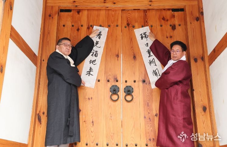 박강수 마포구청장(오른쪽)이 2026년 2월 4일 오전 광흥당 대문에 입춘축을 붙이고 있다.
