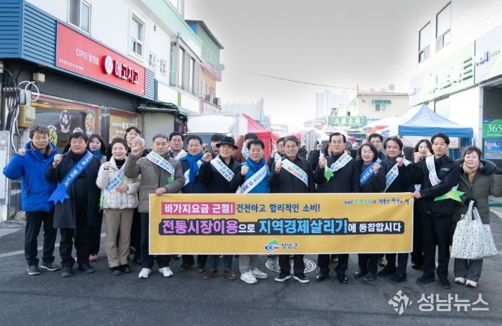 설맞이 전통시장 장보기·물가안정 캠페인을 전개한 참여자들이 단체 기념사진을 촬영하고 있다