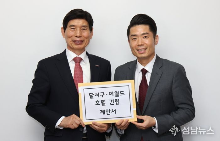 이태훈 달서구청장(왼쪽)이 박동진 이월드 대표(오른쪽)에게 제안서를 전달하고 있다.