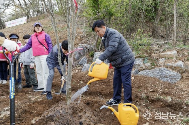 지난해 박강수 마포구청장이 상암 야생화정원에 나무를 식재하고 물을 주고 있다.